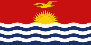 The flag of Kiribati is divided into two halves. While the upper half has a red field, at the center of which is a yellow frigate bird flying over the top half of a rising yellow sun with seventeen visible rays, the lower half is composed of six horizontal wavy bands of white alternating with blue to depict the ocean.